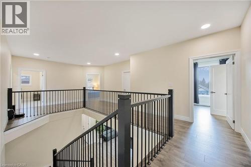 Upper-level landing featuring modern black metal railings, recessed lighting, light wood-finish flooring, and crisp white trim - 6 Dorothys Drive, Oro-Medonte, ON - Indoor Photo Showing Other Room