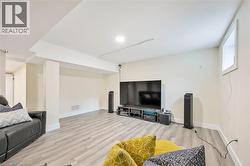 Spacious lower-level room featuring light wood-finish flooring, recessed lighting, and a neutral color palette - 