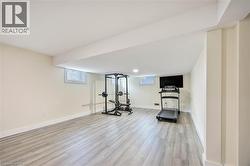 Spacious room featuring light wood-finish flooring, recessed lighting, and bright white baseboards - 
