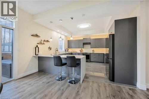 Contemporary kitchen featuring grey cabinetry, stainless steel appliances, a white quartz island with seating, and wood-finish flooring - 6 Dorothys Drive, Oro-Medonte, ON - Indoor Photo Showing Kitchen With Upgraded Kitchen