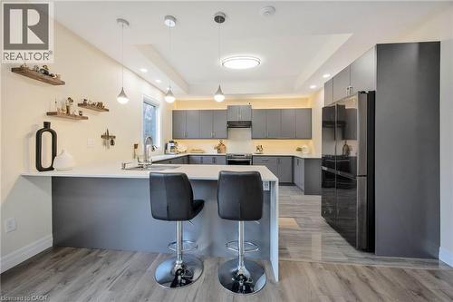 Open-concept kitchen featuring gray cabinetry, stainless steel appliances, white countertops, and wood-finish flooring - 6 Dorothys Drive, Oro-Medonte, ON - Indoor Photo Showing Kitchen With Upgraded Kitchen