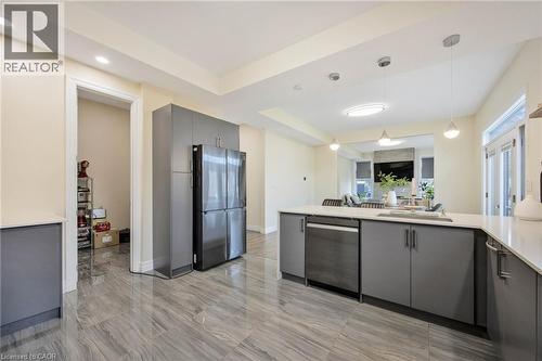 Open-concept kitchen featuring gray cabinetry, stainless steel appliances, a large island with sink, and light-toned countertops - 6 Dorothys Drive, Oro-Medonte, ON - Indoor Photo Showing Kitchen With Upgraded Kitchen