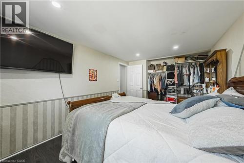 Recessed lighting illuminates this space featuring dark wood-finish flooring and a white paneled door - 235 Larch Street, Hamilton, ON - Indoor Photo Showing Bedroom
