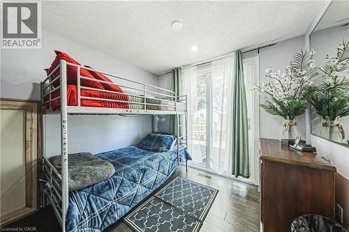 Room featuring dark wood-finish flooring, light-colored walls, and a recessed ceiling light - 235 Larch Street, Hamilton, ON - Indoor Photo Showing Bedroom