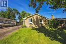 Exterior featuring a brick facade, pitched roofline, front lawn, and mature trees - 235 Larch Street, Hamilton, ON  - Outdoor 