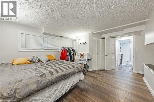 Spacious room featuring wood-finish flooring, white walls, and a textured ceiling - 235 Larch Street, Hamilton, ON - Indoor Photo Showing Bedroom