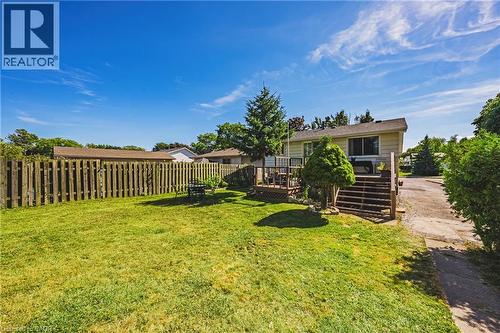 Expansive backyard featuring a lush lawn, privacy fencing, and a multi-level wood deck with stairs - 235 Larch Street, Hamilton, ON - Outdoor