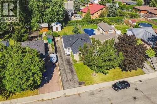 Property featuring a dark shingle roof, mature trees, and a paved driveway - 235 Larch Street, Hamilton, ON - Outdoor