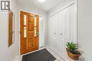 Front entry featuring a paneled wood-finish door with decorative glass inserts and a frosted sidelight - 235 Larch Street, Hamilton, ON  - Indoor Photo Showing Other Room 