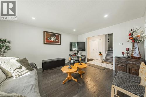 Living area featuring dark wood-finish flooring, recessed ceiling lighting, and a neutral wall color - 235 Larch Street, Hamilton, ON - Indoor Photo Showing Living Room