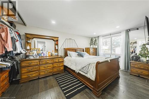 Bedroom featuring dark wood-finish flooring, recessed lighting, and a large window with natural light - 235 Larch Street, Hamilton, ON - Indoor Photo Showing Bedroom