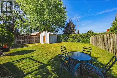 Expansive green lawn with a white storage shed and mature trees - 235 Larch Street, Hamilton, ON - Outdoor With Backyard
