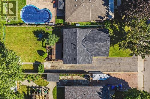 Asphalt shingle roofing, expansive green lawn, wood deck, concrete driveway, and mature trees - 235 Larch Street, Hamilton, ON - Outdoor