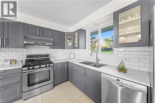 Updated kitchen featuring gray shaker-style cabinetry, white subway tile backsplash, stainless steel appliances, and a double basin sink - 183 Harvard Road, Waterloo, ON - Indoor Photo Showing Kitchen With Double Sink