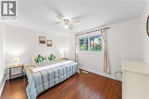Bedroom featuring wood-finish flooring, a window with natural light, a ceiling fan, and white painted walls - 183 Harvard Road, Waterloo, ON - Indoor Photo Showing Bedroom