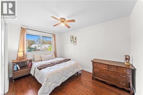 Bright bedroom featuring wood-finish flooring, a ceiling fan with integrated lighting, and white walls - 183 Harvard Road, Waterloo, ON - Indoor Photo Showing Bedroom