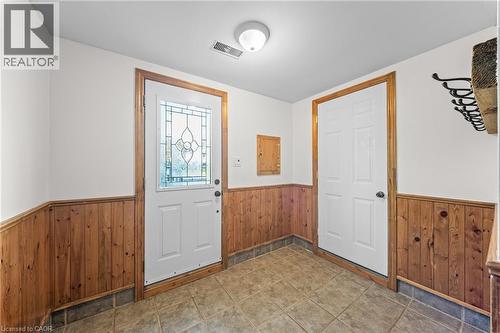 Entryway featuring a decorative glass panel door, wood paneling wainscoting, and tile flooring - 183 Harvard Road, Waterloo, ON - Indoor Photo Showing Other Room