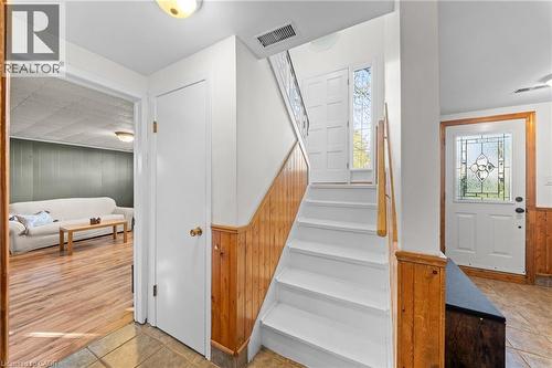 Entryway featuring a white staircase with wood railing, leading to a paneled door with a sidelight - 183 Harvard Road, Waterloo, ON - Indoor Photo Showing Other Room