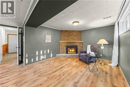 Spacious room featuring wood-finish flooring and paneling walls - 183 Harvard Road, Waterloo, ON - Indoor With Fireplace