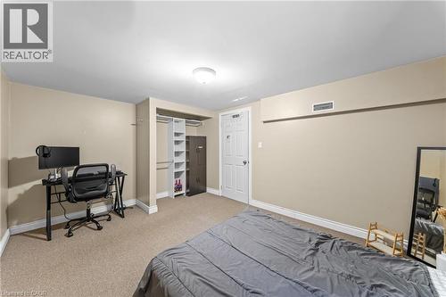 Carpeted room featuring a built-in closet with shelving and hanging rods - 183 Harvard Road, Waterloo, ON - Indoor Photo Showing Bedroom