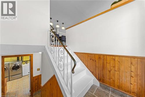 Staircase featuring white risers and treads, decorative wrought iron railing, and a wood-finish handrail - 183 Harvard Road, Waterloo, ON - Indoor Photo Showing Other Room