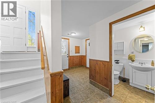 Entryway featuring white paneled door with sidelight, wood-finish wainscoting, and tile flooring - 183 Harvard Road, Waterloo, ON - Indoor Photo Showing Bathroom
