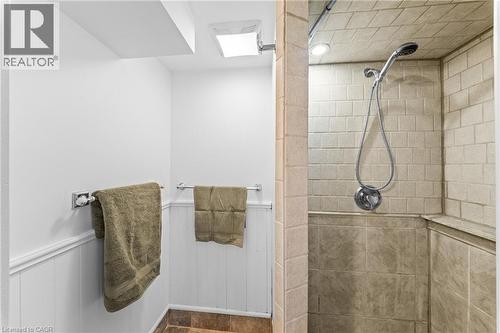 Tiled shower enclosure featuring a handheld showerhead and an integrated shower bench - 183 Harvard Road, Waterloo, ON - Indoor Photo Showing Bathroom