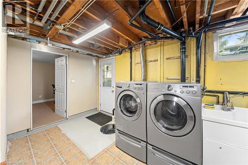 Laundry area with utility sink, tile flooring, and exposed ceiling joists - 183 Harvard Road, Waterloo, ON - Indoor Photo Showing Laundry Room