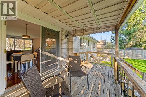 Covered wood deck featuring a white brick exterior and wooden railings - 183 Harvard Road, Waterloo, ON - Outdoor With Deck Patio Veranda With Exterior