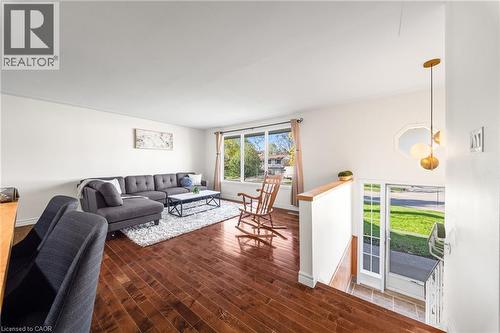 Spacious living area featuring rich wood-finish flooring and ample natural light from large windows - 183 Harvard Road, Waterloo, ON - Indoor Photo Showing Living Room