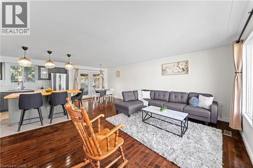 Open-concept living space featuring wood-finish flooring, a kitchen island with pendant lighting, and French doors leading to an exterior area - 183 Harvard Road, Waterloo, ON - Indoor Photo Showing Living Room