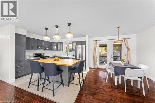 Kitchen featuring dark grey cabinetry, stainless steel appliances, a white subway tile backsplash, and a light wood-finish island - 183 Harvard Road, Waterloo, ON - Indoor Photo Showing Other Room