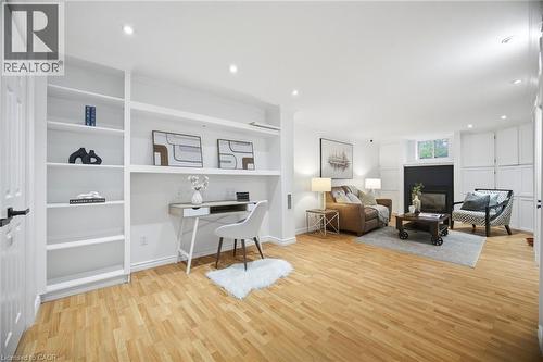 Open-concept living space featuring wood-finish flooring, recessed lighting, and a built-in shelving unit with desk alcove - 1376 Royal Drive, Burlington, ON - Indoor