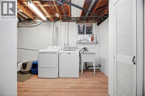 Laundry area featuring wood-finish flooring and exposed ceiling joists - 1376 Royal Drive, Burlington, ON - Indoor Photo Showing Laundry Room