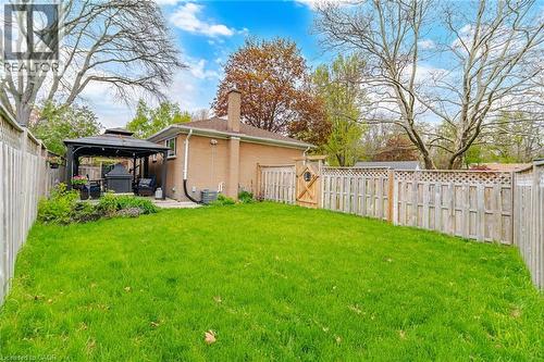 Expansive lawn area featuring a paved patio with a gazebo, mature trees, and privacy fencing - 1376 Royal Drive, Burlington, ON - Outdoor With Deck Patio Veranda