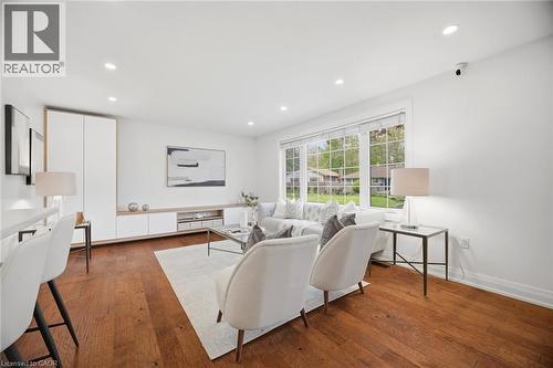 Spacious living area featuring rich wood-finish flooring, a large multi-pane window, and recessed ceiling lights - 1376 Royal Drive, Burlington, ON - Indoor Photo Showing Living Room