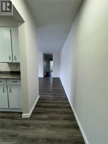Open interior featuring wood-finish flooring, light-toned walls, and white baseboards - 232 Louisa Street Unit# 9A, Kitchener, ON - Indoor Photo Showing Other Room