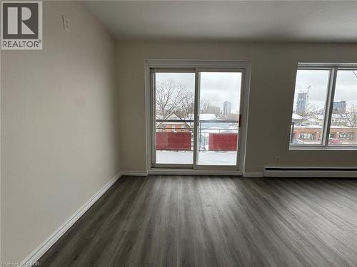 Spacious room featuring wood-finish flooring, white baseboards, and neutral wall paint - 232 Louisa Street Unit# 9A, Kitchener, ON - Indoor Photo Showing Other Room