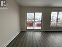 Spacious room featuring wood-finish flooring, white baseboards, and neutral wall paint - 232 Louisa Street Unit# 9A, Kitchener, ON  - Indoor Photo Showing Other Room 