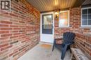 Covered front entrance featuring multi-toned brickwork, a white door with an upper glass panel, and a built-in wall lantern - 27 Max Becker Drive, Kitchener, ON  - Outdoor With Exterior 