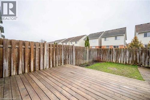Expansive outdoor wood deck with a privacy fence, complemented by a patch of green lawn - 27 Max Becker Drive, Kitchener, ON - Outdoor With Deck Patio Veranda