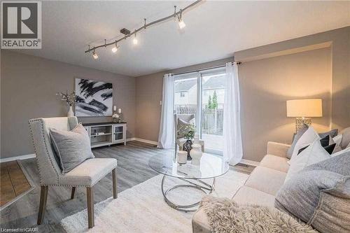 Open-concept living space with wood-finish flooring, neutral wall tones, and recessed track lighting - 27 Max Becker Drive, Kitchener, ON - Indoor Photo Showing Living Room