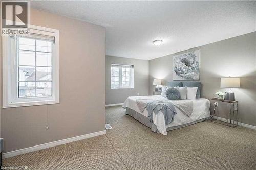Spacious bedroom featuring light neutral wall paint and textured carpet flooring - 27 Max Becker Drive, Kitchener, ON - Indoor Photo Showing Bedroom