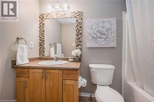 Bathroom featuring a light wood vanity with a built-in sink, a speckled countertop, and a mosaic-framed mirror - 27 Max Becker Drive, Kitchener, ON - Indoor Photo Showing Bathroom