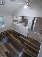 Open concept living space featuring wood-finish flooring and a vaulted ceiling - 