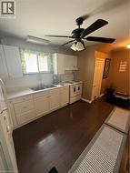 Kitchen featuring white cabinetry, a dual basin stainless steel sink, and wood-finish flooring - 