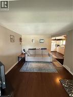 Spacious living area featuring rich wood-finish flooring and neutral wall tones - 