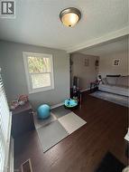 This room features wood-finish flooring and a window with blinds - 