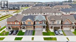 Brick and siding residential property with an attached two-car garage, a paved driveway, and a front lawn - 
