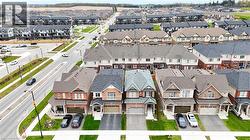 Aerial perspective showcasing a residential street lined with detached homes and townhouses - 